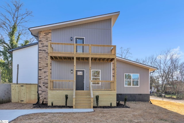 view of front of home with a balcony, fence, covered porch, and crawl space