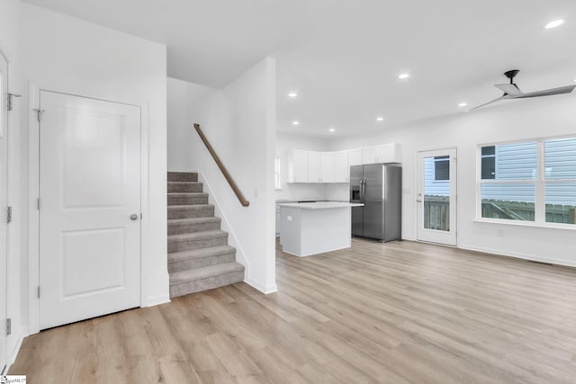 unfurnished living room featuring baseboards, stairway, light wood-type flooring, recessed lighting, and a ceiling fan