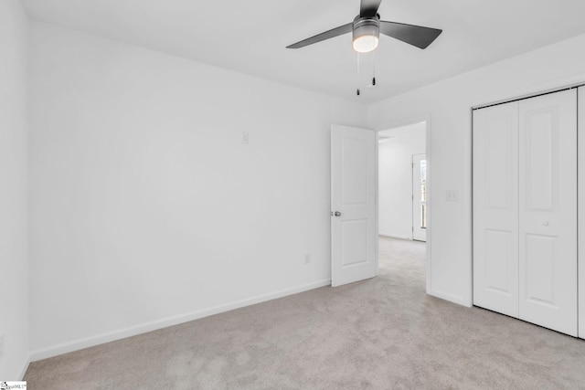 unfurnished bedroom featuring light colored carpet, a closet, and ceiling fan