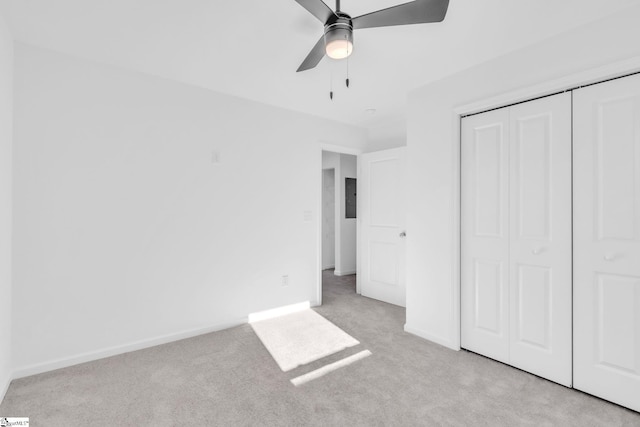 unfurnished bedroom with light colored carpet, ceiling fan, and a closet