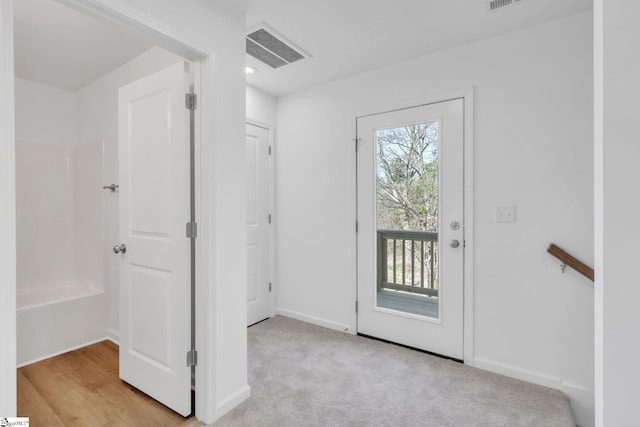 doorway to outside with light carpet