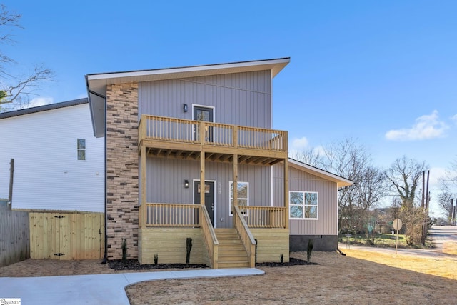 view of front of property featuring a balcony and covered porch