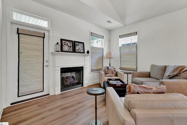 living room featuring vaulted ceiling and light hardwood / wood-style flooring