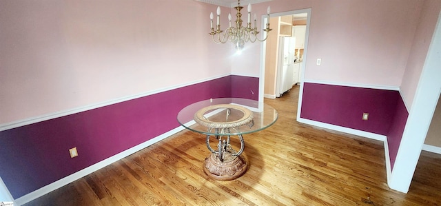 unfurnished dining area featuring hardwood / wood-style floors and an inviting chandelier