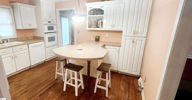 kitchen with white cabinetry, hanging light fixtures, white appliances, and dark hardwood / wood-style floors