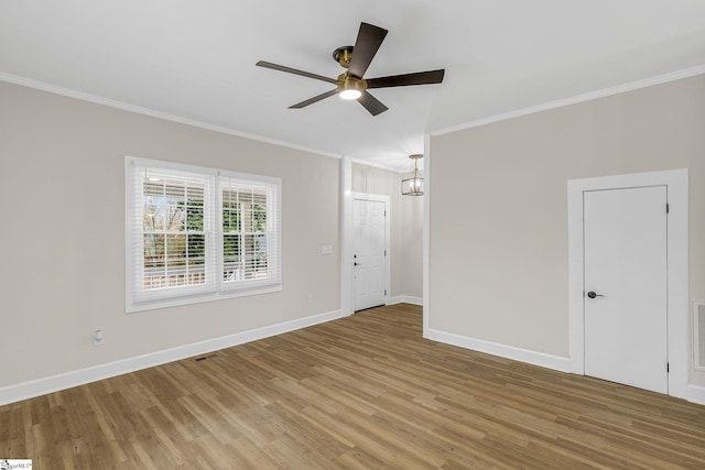 spare room with crown molding, hardwood / wood-style floors, and ceiling fan