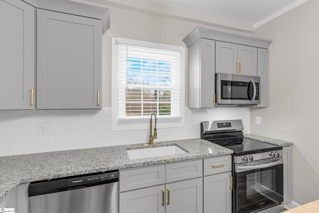 kitchen featuring sink, backsplash, stainless steel appliances, crown molding, and light stone countertops