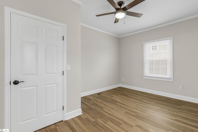 spare room featuring ornamental molding, wood-type flooring, and ceiling fan