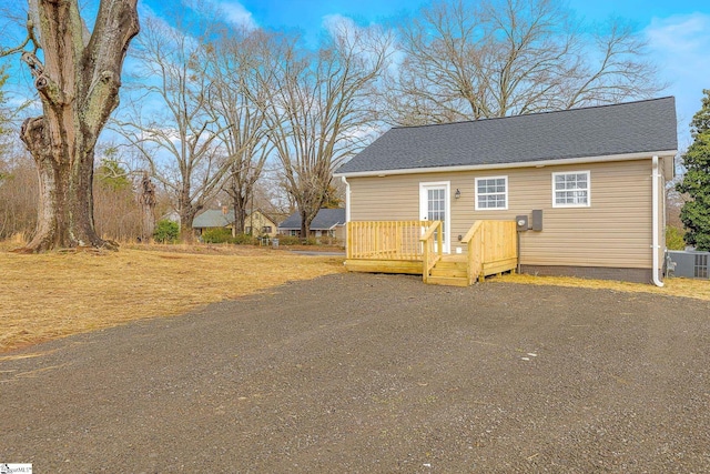 view of front of home with a wooden deck and central AC