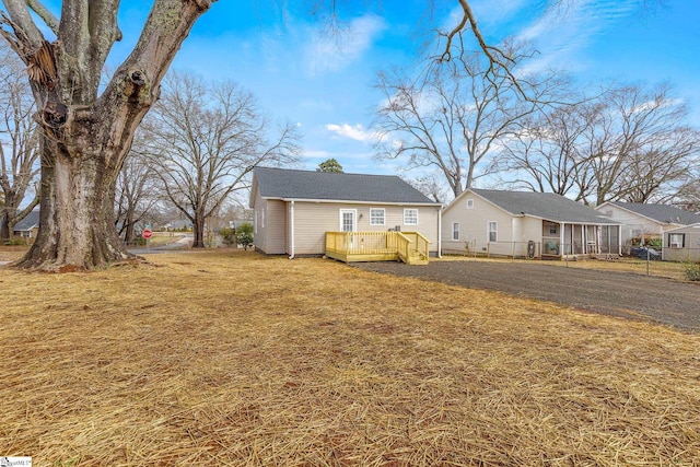 view of front of home with a wooden deck and a front lawn