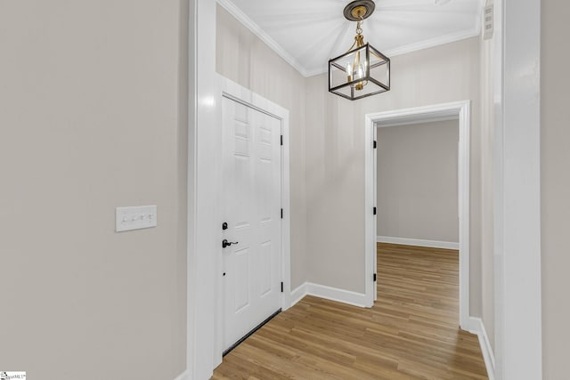 entryway featuring crown molding, an inviting chandelier, and light hardwood / wood-style floors