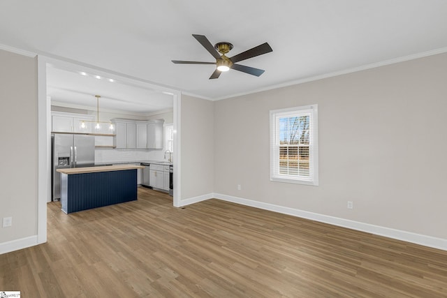 interior space featuring ornamental molding, ceiling fan, and light hardwood / wood-style flooring