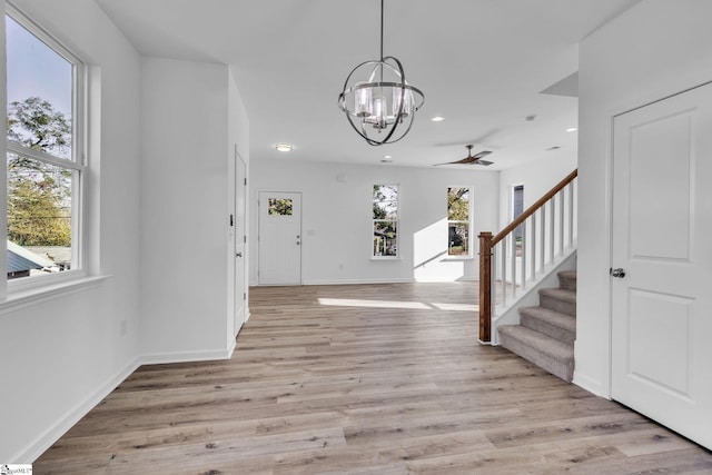 foyer with an inviting chandelier, plenty of natural light, and light hardwood / wood-style flooring