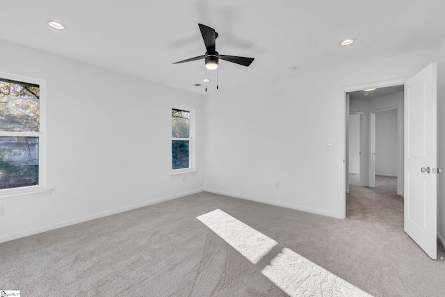 carpeted spare room featuring ceiling fan