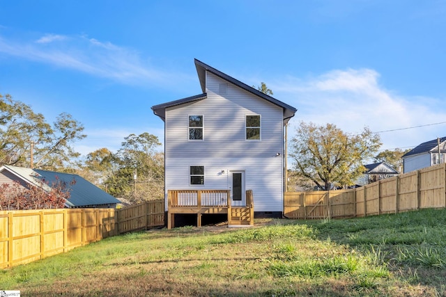 rear view of property with a wooden deck and a yard