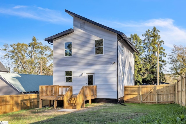 back of property with a wooden deck and a yard