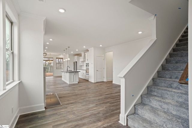 interior space featuring crown molding, stairs, dark wood-type flooring, and recessed lighting