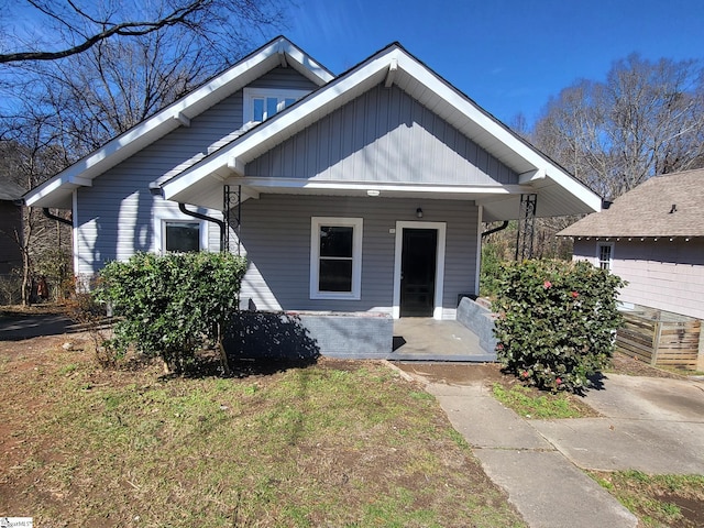 bungalow featuring a porch and a front lawn