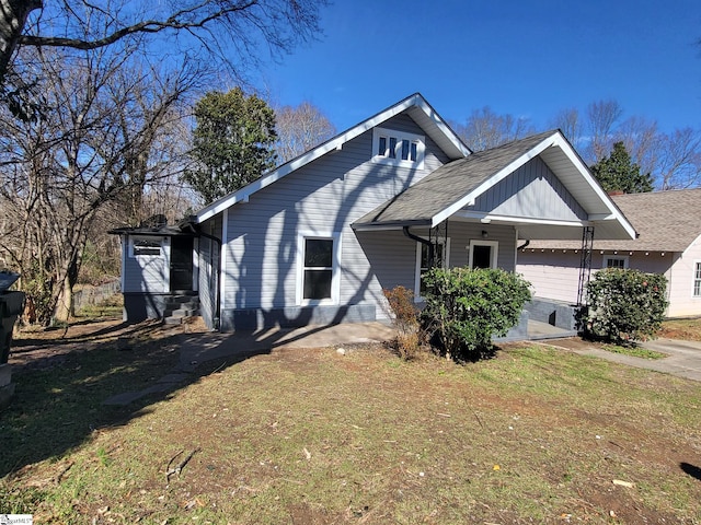 view of side of property featuring a garage and a lawn