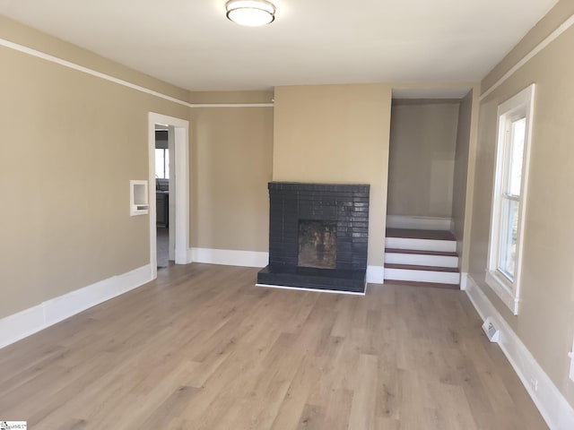 unfurnished living room with a fireplace and light hardwood / wood-style flooring