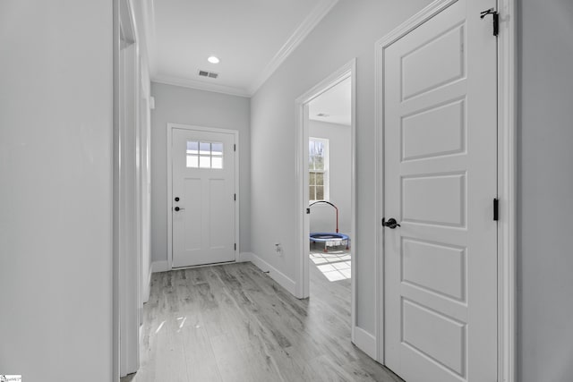 entrance foyer with ornamental molding and light wood-type flooring