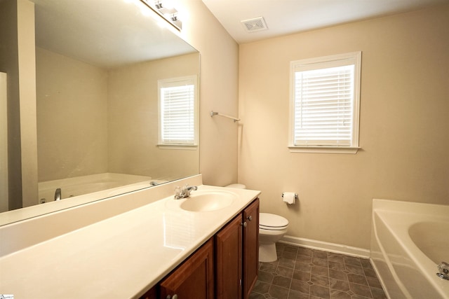 bathroom with vanity, a bathtub, and toilet