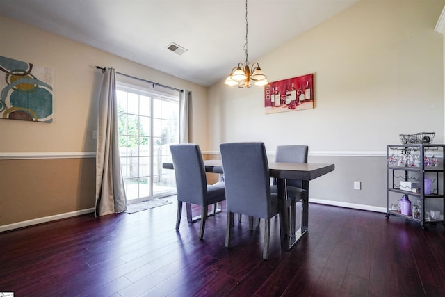 dining space featuring lofted ceiling, dark wood-type flooring, and a notable chandelier