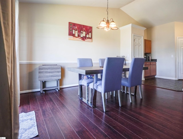 dining area with dark hardwood / wood-style flooring, lofted ceiling, and an inviting chandelier