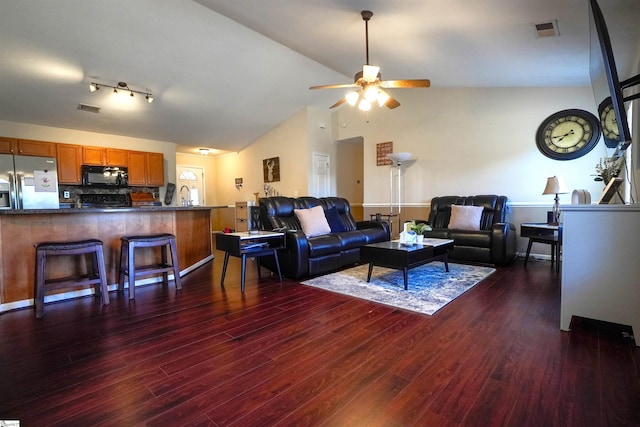 living room with ceiling fan, dark hardwood / wood-style floors, and vaulted ceiling