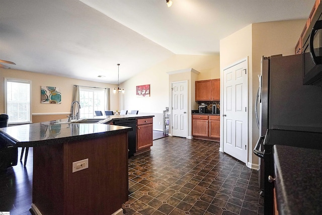 kitchen with vaulted ceiling, pendant lighting, sink, a kitchen island with sink, and black appliances