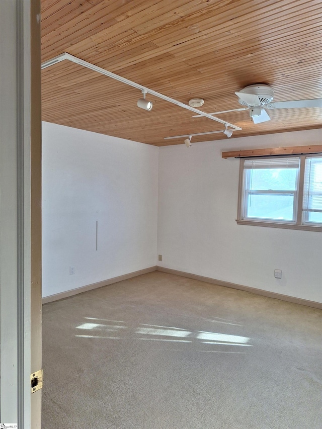 spare room featuring baseboards, carpet, and wood ceiling