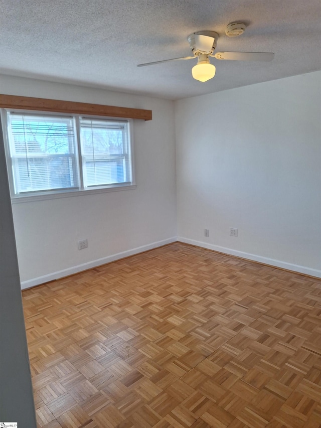 empty room with baseboards, a textured ceiling, and ceiling fan