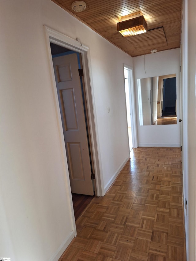 hallway featuring wood ceiling and baseboards