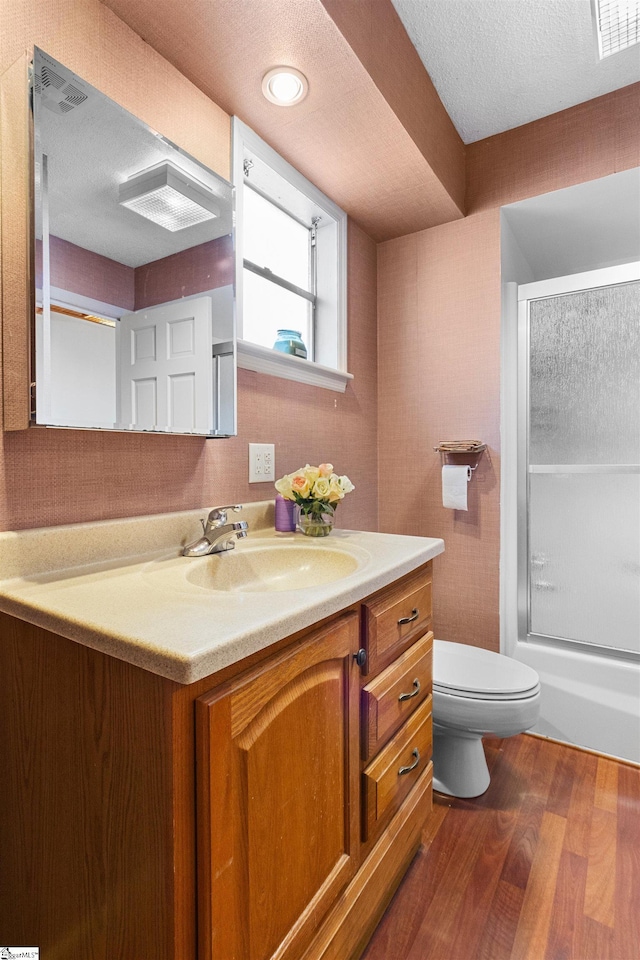bathroom featuring vanity, wood finished floors, visible vents, a textured ceiling, and toilet
