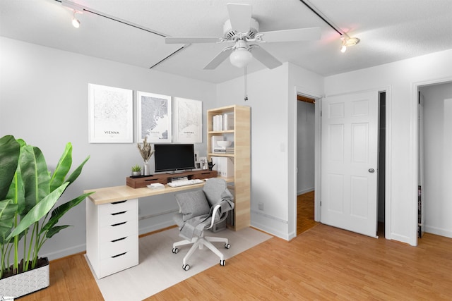 office space featuring track lighting, light wood-style flooring, baseboards, and ceiling fan