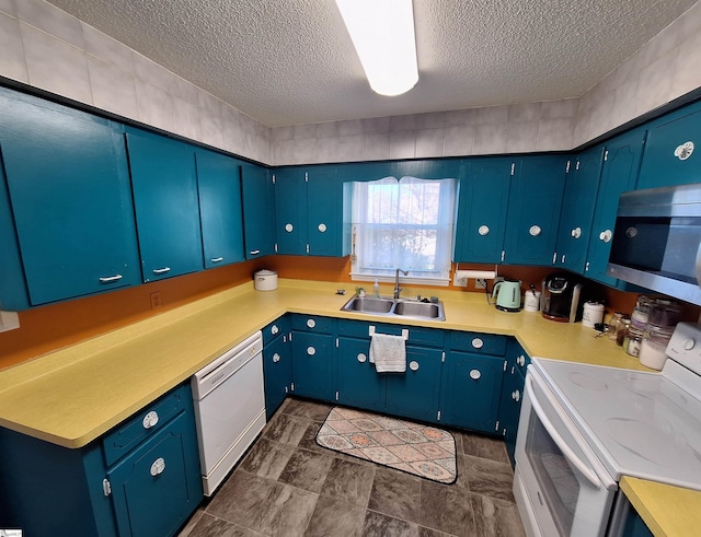 kitchen with white appliances, a textured ceiling, light countertops, and a sink