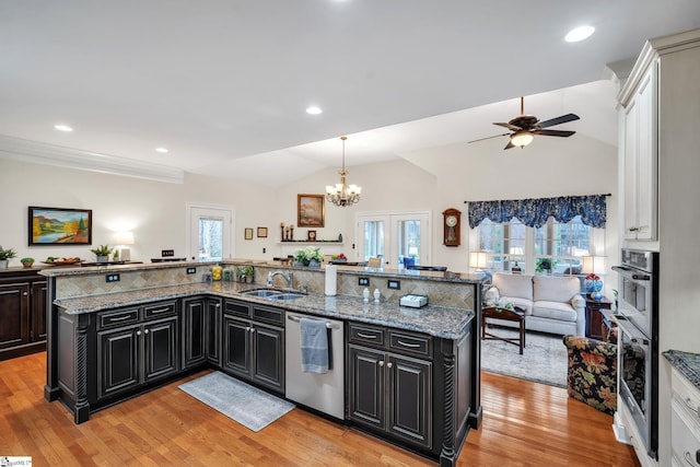 kitchen with sink, appliances with stainless steel finishes, an island with sink, a healthy amount of sunlight, and decorative light fixtures