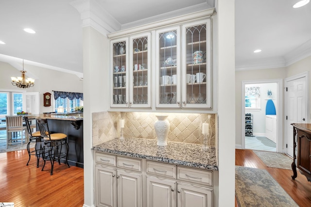 kitchen featuring crown molding, decorative backsplash, a healthy amount of sunlight, and light wood-type flooring