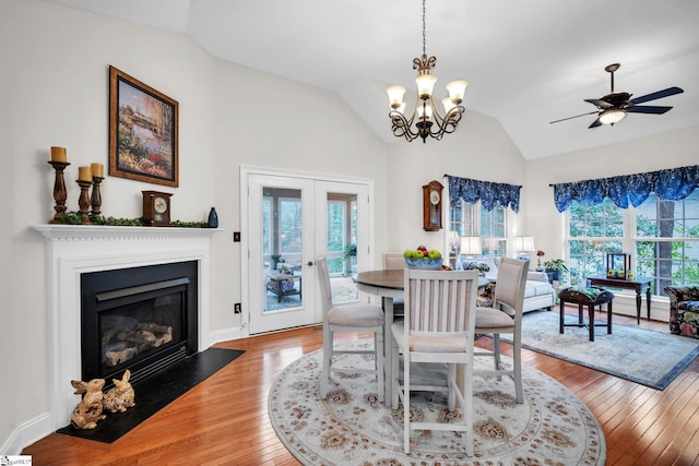 dining space featuring wood-type flooring, french doors, a healthy amount of sunlight, and vaulted ceiling