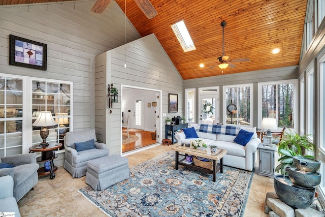 living room with high vaulted ceiling, wooden walls, a skylight, ceiling fan, and wood ceiling