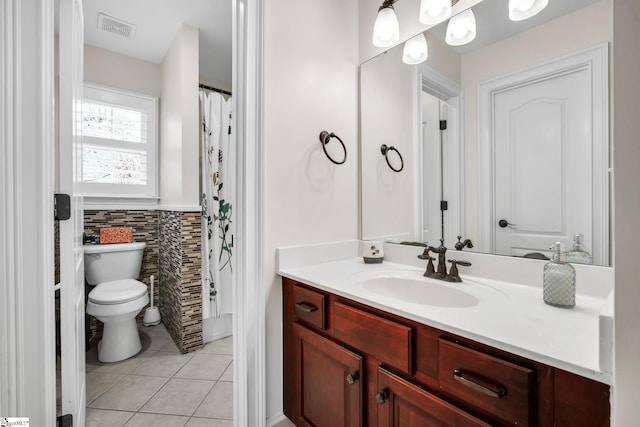 bathroom featuring tile walls, vanity, tile patterned floors, and toilet