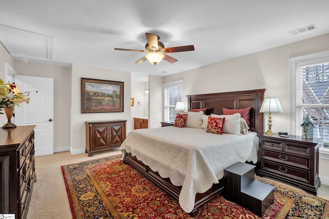 carpeted bedroom with connected bathroom and ceiling fan