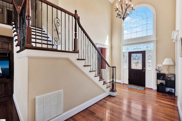 entryway featuring a notable chandelier, hardwood / wood-style floors, and a high ceiling