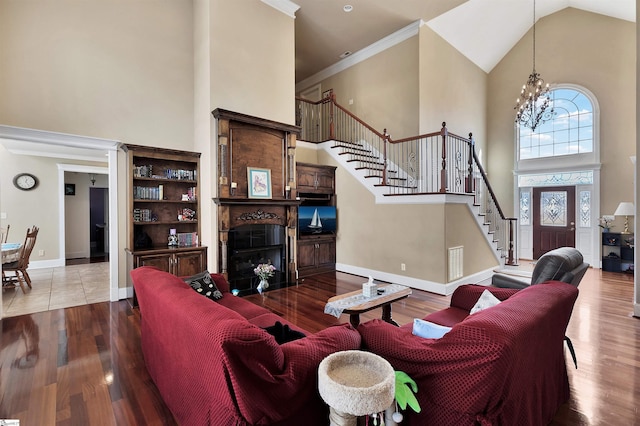 living room with a notable chandelier, crown molding, high vaulted ceiling, and light wood-type flooring