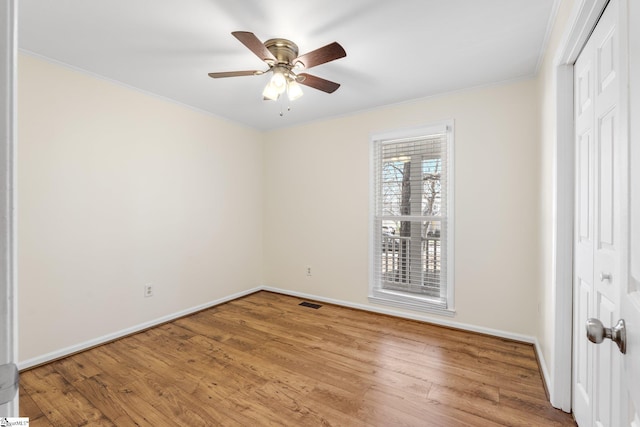 empty room featuring crown molding, ceiling fan, and wood-type flooring