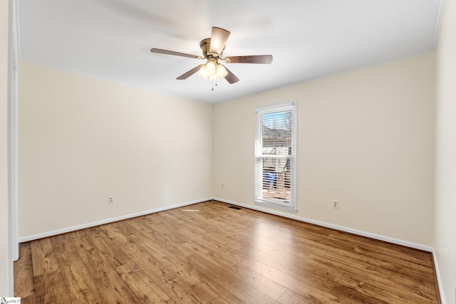 empty room with ceiling fan and light hardwood / wood-style flooring