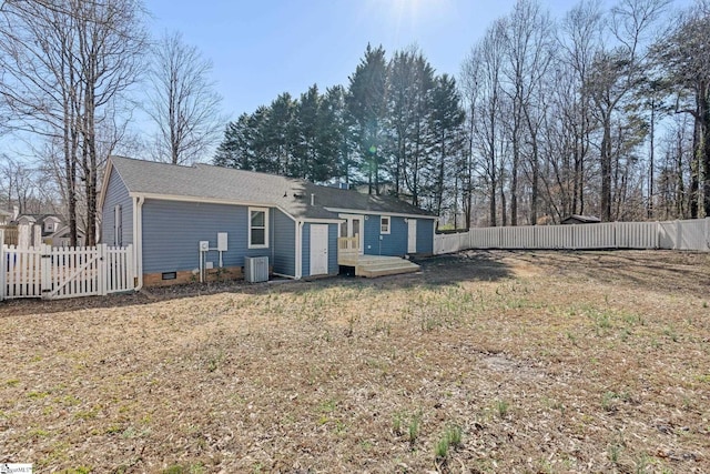 back of property with central AC and a lawn