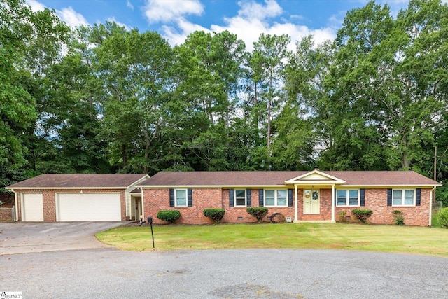 ranch-style home with a garage and a front lawn