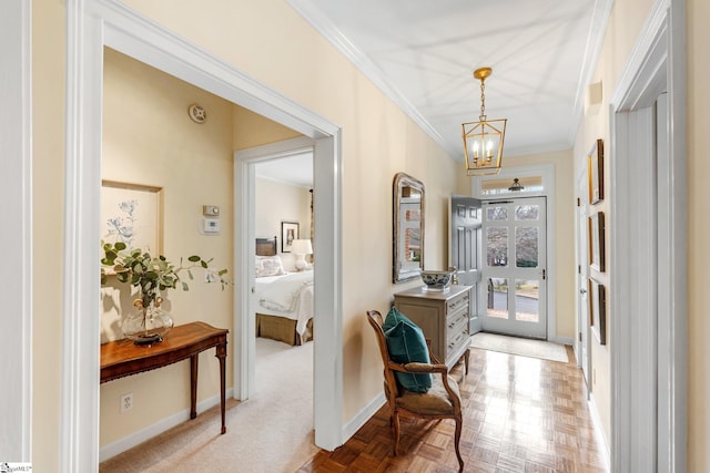 hall with a notable chandelier, crown molding, and light parquet floors