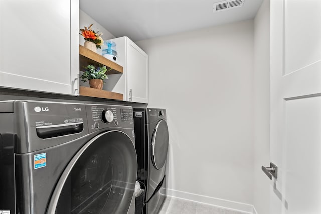 washroom featuring cabinets and washer and dryer